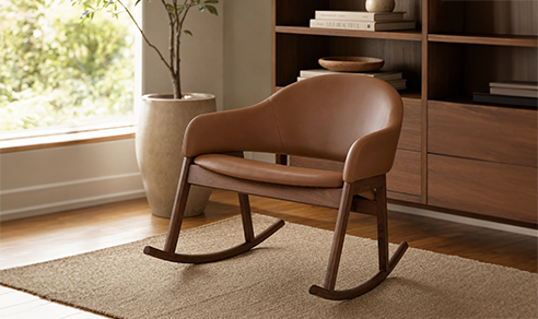 Tan leather rocking chair with walnut wood frame on a woven jute rug